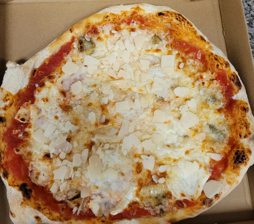 Pizza 4 fromages sur base tomate, garnie de mozzarella, gorgonzola, chèvre et parmesan